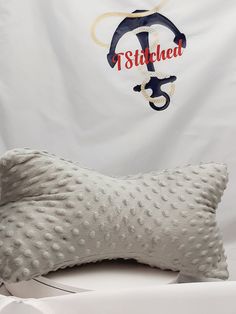 a pillow that is sitting on top of a table next to a white wall with a banner in the background