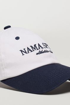 Description Crafted from cotton canvas, this cap features a timeless two-tone finish and an embroidered logo, making it a must-have for your off duty look. 100% cotton twill fabric Adjustable back strap Matte nickel buckle 6 panel Unisex fit 'NAMA SPORT' logo embroidery Complete the look: Body Butter™ Crop Jacket Fabric & Fit 100% Cotton Adjustable fit Model is 5'9", 36" Bust, 28" Waist, 42" Hips, and wears a size small top and medium bottom. Shipping & Returns Visit our Shipping and Returns pag Cotton Baseball Cap With Logo, Cotton Six-panel Hat With Logo, Cotton Hat With Logo And Curved Visor, Cotton Curved Visor Hat With Logo, Cotton Hat With Curved Visor And Logo, Cotton Baseball Cap With Curved Brim And Logo, Adjustable Cotton Hat With Logo, Classic Cotton Baseball Cap With Embroidered Logo, Cotton Six-panel Hat With Logo Print