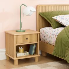 a nightstand with a lamp next to it on top of a wooden bed in a bedroom