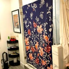 a bathroom with a shower curtain that has flowers on it