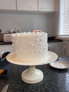 a white frosted cake sitting on top of a counter