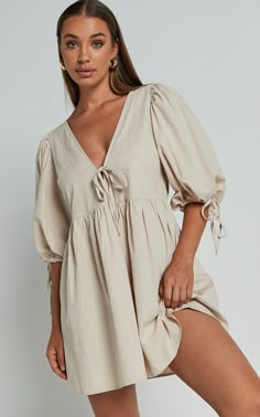 Turn heads in our Rosita Mini Dress! This tie front puff sleeve dress in stone is the perfect addition to your casual weekend activities. Made from comfortable cotton, this V-neck mini dress features 3/4 sleeves for a chic and stylish look. Its neutral color makes it easy to pair with any accessories or shoes, giving you endless options for creating different outfits. Whether you're meeting friends for brunch or running errands around town, the Rosita Mini Dress will keep you looking effortlessl Beige V-neck Cotton Mini Dress, Beige Cotton V-neck Mini Dress, Cotton V-neck Puff Sleeve Dress For Brunch, Brunch Dress Outfit, Doc Fits, Nursing Outfits, Outfits For Spain, Linen Casual Dress, Splendid Dress