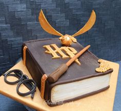 a cake made to look like an old book with scissors and other items on it