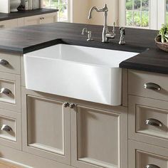 a white kitchen sink sitting on top of a counter next to a black countertop