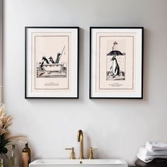 two framed pictures hang above a sink in a bathroom