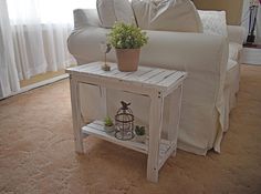 a living room with a couch, coffee table and white sofa in it's corner