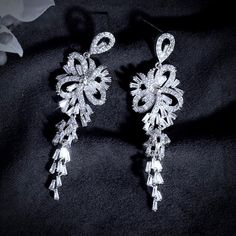 A delightfully unique pair of bridal earrings with an incredible sparkle! Adorned with flawlessly faceted cubic zirconia that capture the light in a dazzling array of sparkles, the earrings are rhodium plated for a bright finish which enhances the intricate detailing and conveys a modern take on old elegance. Length: 60mm (approx. 2.3"). Width: 18mm (approx. 0.7"). Weight: 11g. Available in Silver and Rose Gold finishes. To make your choice select your preferred finish from the dropdown menu to Cubic Zirconia Bridal Earrings, Silver Wedding Jewelry, Bridal Earrings, Exquisite Design, Gold Finish, Rhodium Plated, Wedding Jewelry, Cubic Zirconia, Silver Jewelry