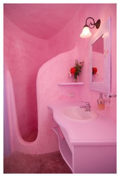 a pink bathroom with curved walls and sink