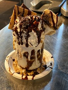 an ice cream sundae with chocolate drizzle and marshmallows on top