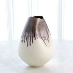 a white and black vase sitting on top of a table