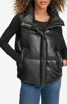 Timeless channel quilting adds a classic look to this faux-leather puffer vest to keep you cozily warm. 23" length (size Medium) Front zip closure with snap storm placket Stand collar Front welt pockets Lined, with polyester fill 100% polyester with polyurethane coating Machine wash, tumble dry Imported Faux Leather Puffer Vest, Leather Puffer Vest, Rains Long Jacket, Leather Puffer, Leather Denim, Outerwear Vest, Favorite Sweater, Levis Women, Designer Clothes For Men