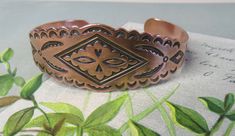 "Here's a nice vintage copper bracelet, with a stamped design with Native American images. This bracelet measures 7/8\" wide in the front, has a 6.1/2\" circumference, including the 1\" back opening. Clean and ready to wear condition with minimal wear to copper finish. Thanks for looking." Vintage Stamped Bronze Bracelets, Vintage Brown Engraved Cuff Bracelet, Vintage Brown Engraved Bracelets, Stamped Copper Cuff Bracelet As Gift, Stamped Copper Cuff Bracelet For Gift, Vintage Copper Bangle Jewelry, Antique Stamped Adjustable Cuff Bracelet, Vintage Copper Cuff Bangle Bracelet, Vintage Copper Bangle Cuff Bracelet