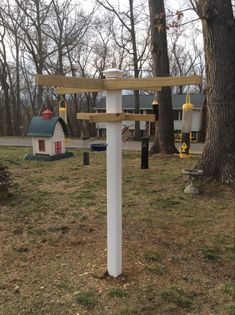 a wooden sign in the middle of a park with houses and playgrounds behind it