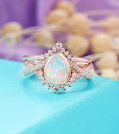 an opal and diamond ring on top of a blue box