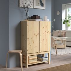 a living room scene with focus on the cabinet and chair next to it's footstool