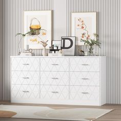 a white dresser sitting next to two pictures on the wall