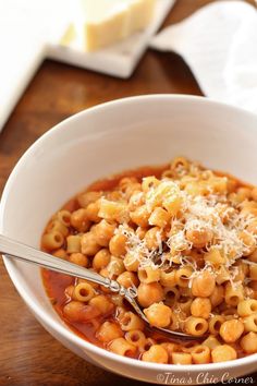 a white bowl filled with macaroni and cheese on top of a wooden table