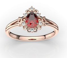 a diamond ring with a red stone in the center