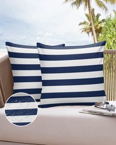 two blue and white striped pillows sitting on top of a couch next to palm trees