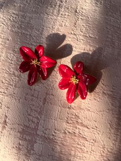 These flower earrings are ye-catching and elegant- featuring a bold, glossy pink design. Each earring is shaped like a flower with five petals, and the petals have a slightly curved, pointed shape, giving the flowers a dynamic, lifelike appearance. The petals are a deep, rich pink a polished, shiny finish, making them stand out beautifully. These earrings are perfect for making a statement, whether for a special occasion or to add a pop of color and elegance to everyday outfits. They have a soph Elegant Rose Red Flower-shaped Earrings, Red Flower-shaped Earrings For Party, Red Floral Earrings For Party, Red Flower Shape Earrings For Party, Red Flower-shaped Party Earrings, Red Flower Shaped Party Earrings, Flower Charm Earrings For Party, Red Flower Charm Earrings, Red Drop Earrings With Flower Charm