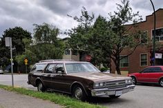 an old station wagon is parked on the side of the road