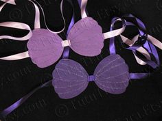 purple and white ribbons with bows on black background, one ribbon tied to the other