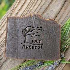 a piece of wood with the words 100's natural on it and some lavender flowers