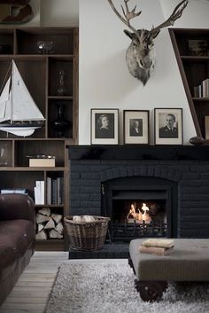 a living room filled with furniture and a fire place in front of a book shelf