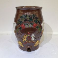 a vase with flowers and animals painted on the outside, sitting on a white surface