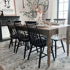 a dining room table set with black chairs