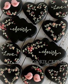 heart shaped cookies are decorated with flowers and the word love is spelled in cursive writing