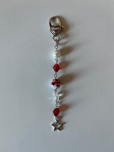 a red and white beaded keychain hanging from a hook on a wall