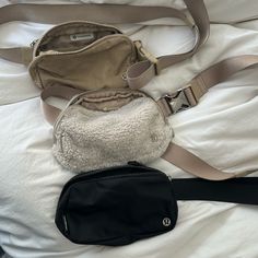 two purses are laying on a white sheet