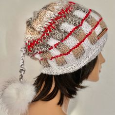 a mannequin head wearing a hat with fur pom - poms on it