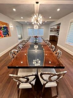 a dining room table with chairs and a chandelier hanging from the ceiling