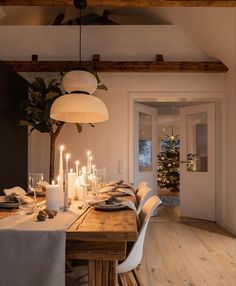 a dining room table is set with candles and place settings for six people to sit at