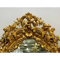 an ornate gold mirror with cherubs on it