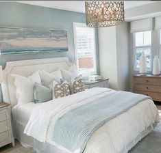 a bedroom with blue walls, white bedding and gray carpeted area rugs