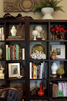 a bookcase filled with lots of books and vases