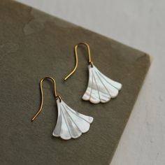 These beautiful Art Deco earrings are pure Mother of Pearl which has been carved into a simple scalloped fan shape. The pearl has an incredible sheen and take on a subtle glow when they catch the light. They are finished with gold plated earwires and are designed to hang just below the earlobe. The length of the earrings is around 45mm (just under two inches). 🖤 FASTER SHIPPING 🖤 Need this fast? We offer a Faster Shipping option here: https://www.etsy.com/uk/listing/100107311/faster-shipping-p Elegant Shell-shaped Wedding Earrings, White Art Deco Earrings For Anniversary, Elegant Shell-shaped Jewelry With Ear Wire, Gold Art Deco Earrings, Egyptian Necklace, Art Nouveau Earring, Earrings Art Deco, Wedding Day Jewelry, Deco Earrings