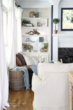 a living room filled with furniture and a fire place in the middle of it's wall