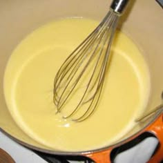 a whisk is being stirred in a pan on the stove