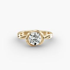 a yellow gold ring with a round diamond in the center, on a white background