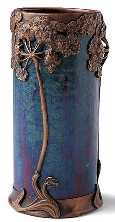 a blue vase with flowers and vines on it