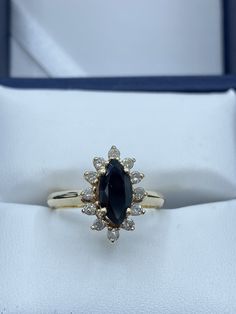 an engagement ring with a large blue stone surrounded by small white diamonds in a box