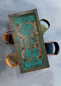 an overhead view of a wooden table with chairs and a blue tile design on it