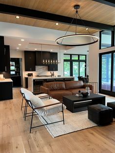 a living room filled with furniture next to a kitchen and an open concept floor plan