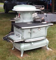 an old fashioned stove sitting in the grass