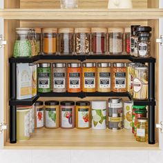 an organized spice rack in a kitchen with spices and seasonings on the bottom shelf