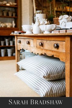 a wooden table topped with lots of pillows